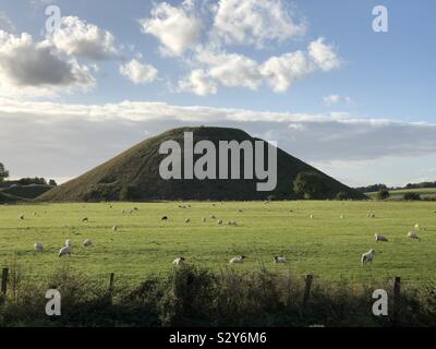 Une vue de Silbury Hill, chalk préhistorique, avec des moutons dans un pré en premier plan. Banque D'Images