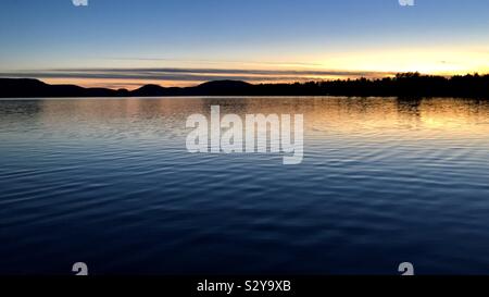 D'incandescence sur le lac Pleasant après le coucher du soleil sur une calme soirée d'automne Banque D'Images