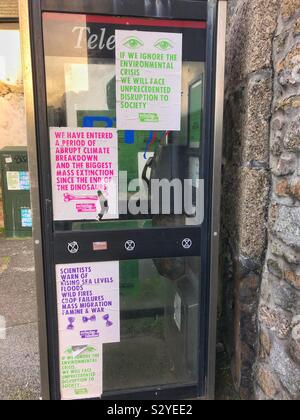 Rébellion d'extinction d'affiches et d'autocollants sur une cabine téléphonique, St Ives, Cornwall. Banque D'Images