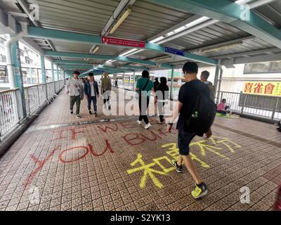 Les piétons circulant sur des slogans graffiti peint par manifestants exiger leurs droits à Hong Kong. Banque D'Images