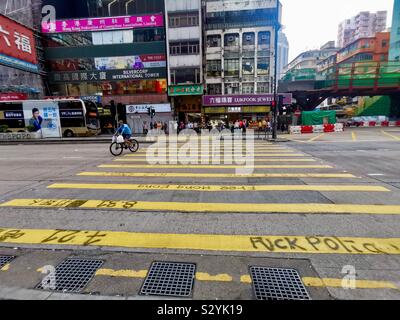 Les piétons circulant sur des slogans graffiti peint par manifestants exiger leurs droits à Hong Kong. Banque D'Images