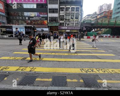 Les piétons circulant sur des slogans graffiti peint par manifestants exiger leurs droits à Hong Kong. Banque D'Images