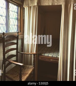 Chaise et lit dans le Jabez Howland House, Plymouth, Massachusetts, United States. La maison a été construite en 1667 et achetée par Jabez Howland, le fils de deux passagers Mayflower. Banque D'Images