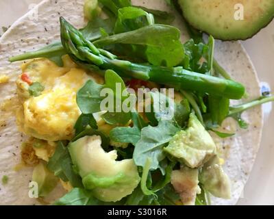 Tortilla de farine de noix de coco avec des œufs brouillés, roquette, asperge, avocat Banque D'Images
