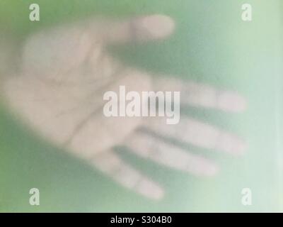 Empreinte de main, l'ombre d'une main derrière le gel vert fond de verre Banque D'Images
