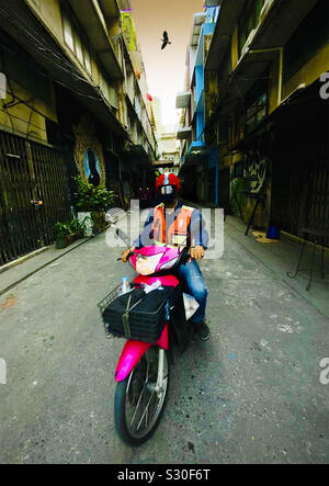 Taxi moto rider dans la ruelle sombre Banque D'Images