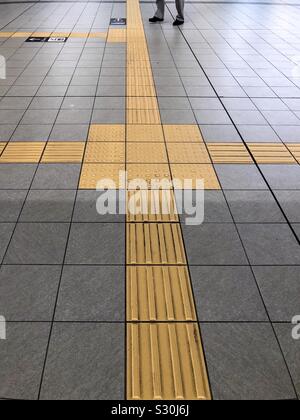 Lignes jaunes appelés indicateurs tactiles de la surface du sol , TGSI , ou blocs Tenji. Dans une station de métro de Tokyo au Japon. Banque D'Images