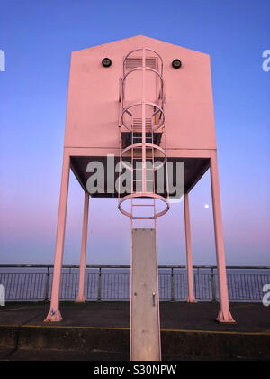 Grand bâtiment rose sur la baie de Cardiff avec barrage lever de lune, décembre. Banque D'Images