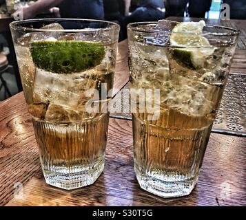 Deux verres de whisky avec le soda au gingembre et citron vert Banque D'Images