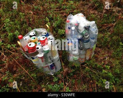 Libre de deux gros sacs remplis de bouteilles en plastique et les cannettes en aluminium pour être recyclé, entouré par des forêts rurales à Stockholm, Suède Banque D'Images