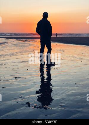 Si un homme Silhouette au coucher du soleil sur une plage à Lincoln City Oregon Banque D'Images