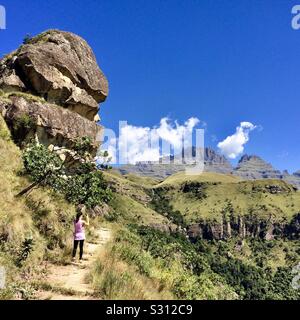 Une jeune femme hiker prend une photo d'un magnifique paysage de montagne tout en explorant le Drakensberg en Afrique du Sud. Banque D'Images