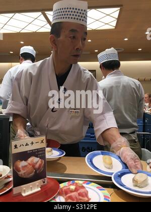 Au chef de sushi sushi bar de la courroie du convoyeur à la gare de Kyoto, Japon. Banque D'Images