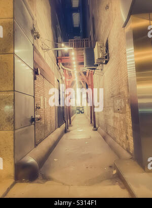 Le centre-ville de ruelle dans la Windy City Chicago pendant l'hiver. Les lumières durant une sombre nuit de vent se distinguent entre tous les bâtiments. Banque D'Images