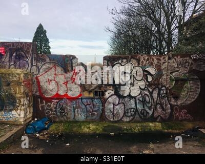 Une clôture en bois couverte de graffitis à New Cross, se London. Banque D'Images