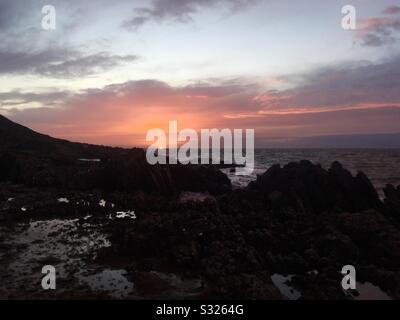 Coucher de soleil sur la mer d'Irlande et les rochers à Port Logan, Dumfries et Galloway, Écosse Banque D'Images