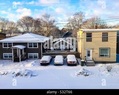 Un matin d'hiver ensoleillé dans une rue résidentielle, avec soleil, neige fraîche et ciel bleu. Concepts: Croustillant, joli, temps froid. Avant le déneigement. Banque D'Images