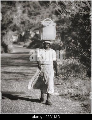 Une femme marche sur le marché en Jamaïque rurale. Banque D'Images