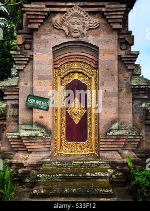 La porte de style kori agung ornée forme l'entrée d'un immeuble résidentiel - avec une chambre à louer - près d'Ubud, Bali, Indonésie Banque D'Images