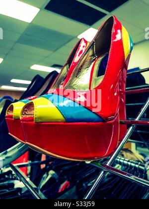 Chaussures brillantes et vives au talon rouge sur un rack dans un magasin prospère Banque D'Images