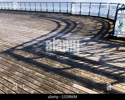 Ombres des rampes sur les planchers en bois de la jetée de Penarth, Pays de Galles du Sud, fin d'après-midi, mars. Banque D'Images