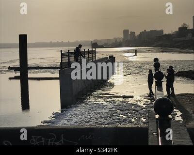 Adolescents sur remblai abandonné pendant la dérive de glace sur la rivière Volga. Début printemps, Saratov, Russie Banque D'Images