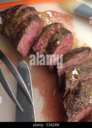 Un steak de jupe rare moyen sculpté sur un tableau de découpe dans une cuisine résidentielle. Banque D'Images