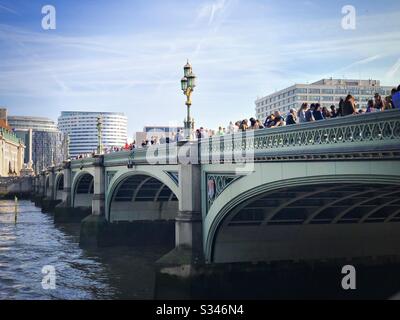 Vue panoramique sur les touristes se tenant sur le pont de Westminster au-dessus de la Tamise, Londres Banque D'Images