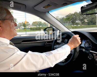 Homme senior conduisant sa voiture. Banque D'Images