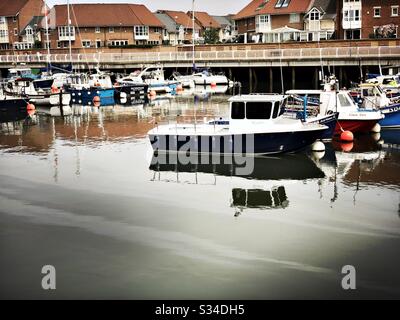 Bateaux de pêche amarrés à une petite marina. Roker Marina, Sunderland, Angleterre du Nord-est. Le déversement d'huile flotte sur de l'eau trouble Banque D'Images