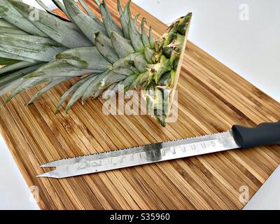 Préparer un ananas entier dans la cuisine. Préparation de fruits frais et mûrs. Ingrédients pour la salsa d'ananas maison. Sur une planche à découper en bois avec couteau Banque D'Images