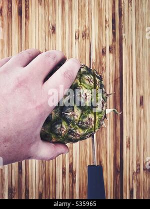 Préparer un ananas entier dans la cuisine. Préparation de fruits frais et mûrs. Ingrédients pour la salsa d'ananas maison. Sur une planche à découper en bois avec couteau Banque D'Images