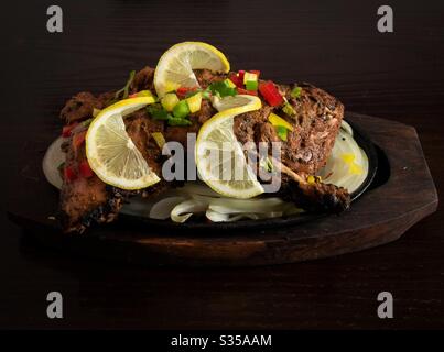 Plaque de poulet tikka sur une table en bois sombre Banque D'Images