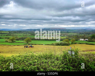 Scène rurale - la muck s'étend sur les terres agricoles de la vallée de Glamourgan, avec la montagne Garth au loin, Pays de Galles du Sud, avril. Banque D'Images