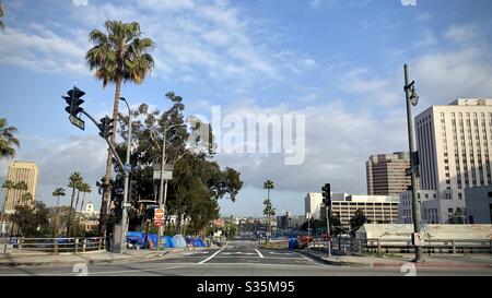 LOS ANGELES, CA, APR 2020: Campement sans abri avec des bâches bleues et des tentes sur le côté d'une route, au-dessus de l'autoroute, près du centre civique du centre-ville Banque D'Images