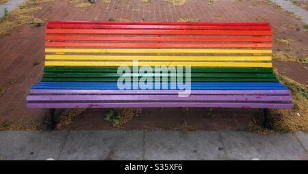 Banc peint en couleurs arc-en-ciel dans la rue Banque D'Images
