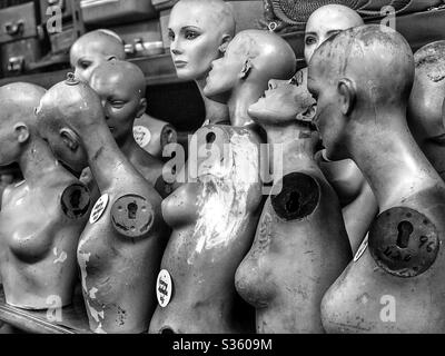 Image en noir et blanc des corps supérieurs de mannequin femelle alignés dans un entrepôt de récupération Banque D'Images