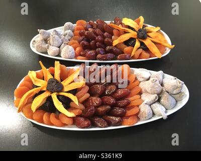 Plateaux de fruits séchés avec motif floral sur des plats d'accompagnement en céramique blanche Banque D'Images