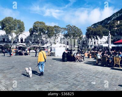 Homme marchant son chien à travers la place Casemates à Gibraltar Banque D'Images