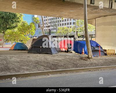 LOS ANGELES, CA, MAI 2020 : vue rapprochée campement sans-abri comprenant plusieurs tentes, près des immeubles de bureaux, des appartements et des hôtels, sous un pont au centre-ville. Banque D'Images