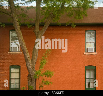 DUBUQUE, IOWA, 26 mai 2020--photo de paysage de la vue latérale d'une ancienne maison en brique rouge avec des fenêtres symétriques avec climatiseur aux deux étages. Banque D'Images