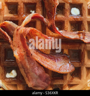 Gros plan avec gaufres, bacon et sirop d'érable et beurre. Petit déjeuner américain. Banque D'Images