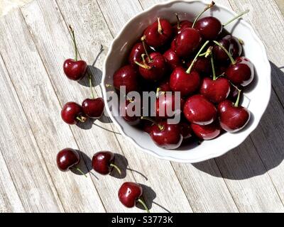 Les cerises dans un bol blanc Banque D'Images