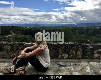 Woman est assise sur un mur de roche au Grove Park Inn, en regardant sur Asheville et la forêt Biltmore dans les Blue Ridge Mountains de Caroline du Nord 7.1.2017 Banque D'Images