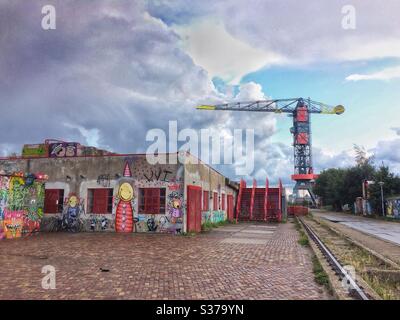 Amsterdam, NDSM-plein avec des œuvres d'art de rue sur les murs de ce quartier d'entrepôt et la boutique Crane Hotel Farada en arrière-plan Banque D'Images