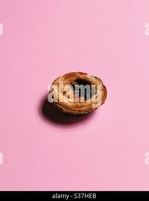 Pâtes de nata, tarte à la crème portugaise sur fond rose Banque D'Images