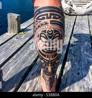 Tatouage artistique avec un motif polynésien. Homme blanc debout sur un quai au-dessus de l'océan Atlantique, Nouvelle-Écosse, Canada. Fusion culturelle, célébration, respect. Banque D'Images