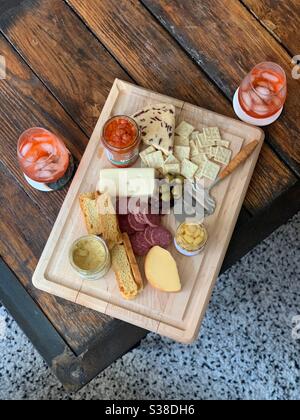 Une vue en hauteur d'un plateau de charcuterie avec fromages, salami, olives, etc. Et deux verres de vin Banque D'Images