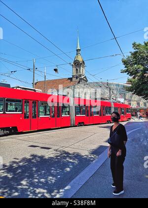 Femme en masque noir avec tram rouge, Berne, Suisse Banque D'Images