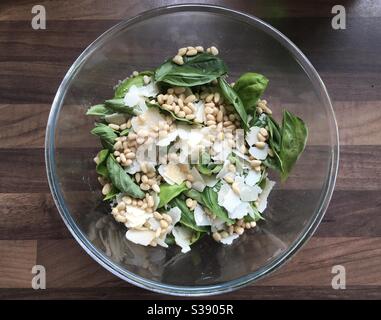 Ajoutez simplement de l'huile : des ingrédients frais de pesto de basilic dans un bol en verre Banque D'Images